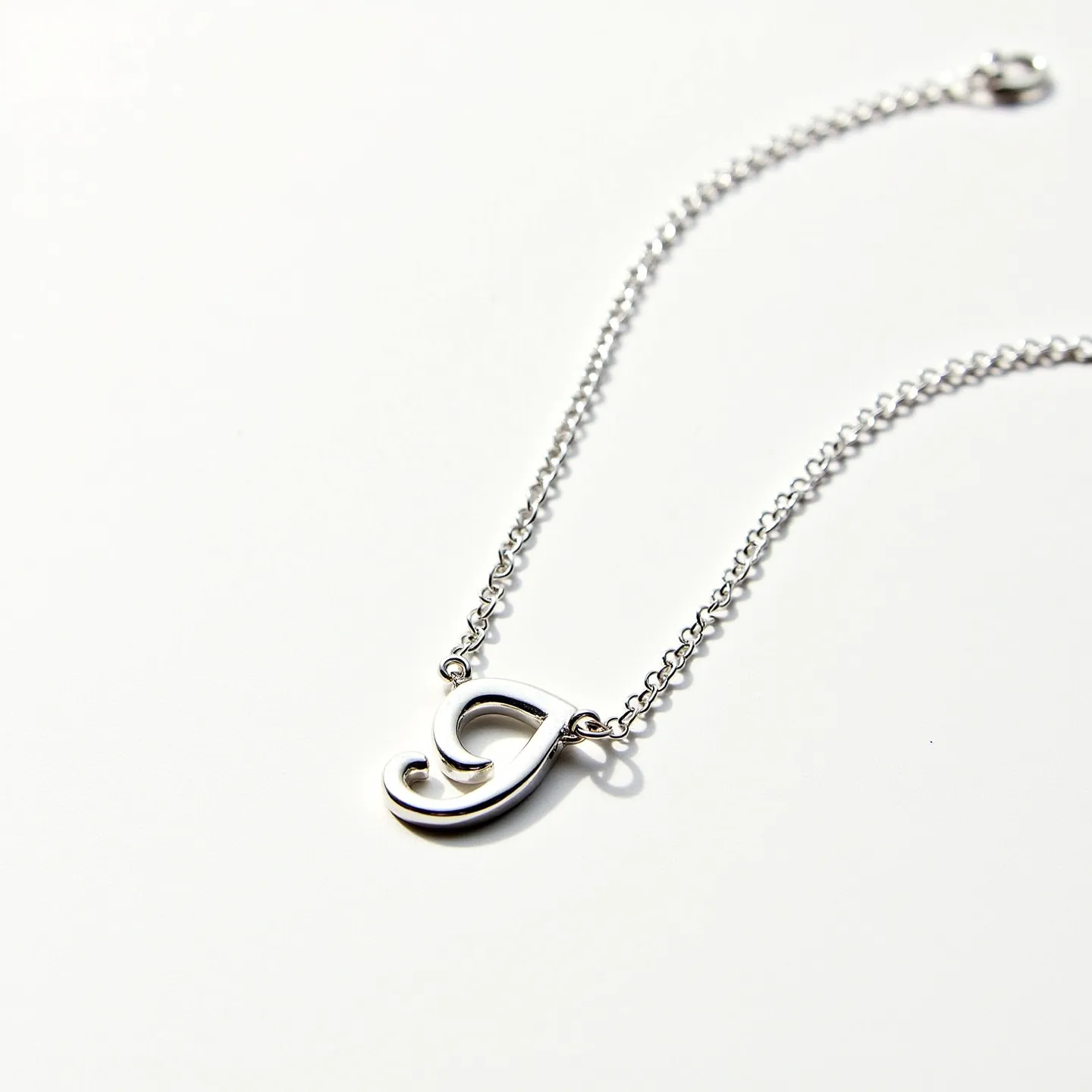 This silver initial necklace features a stylishly crafted pendant in the form of an initial, made from polished silver that gives it a sleek and elegant appearance. The initial is integrated into a fine chain, also crafted from silver, providing a cohesive and refined look. The chain comprises small, interlocking links that are both durable and delicate, ensuring a comfortable wear. Attached to the end of the chain is a classic round spring ring clasp, which secures the necklace with ease. The simplicity and elegance of this piece make it a versatile accessory suitable for various occasions.