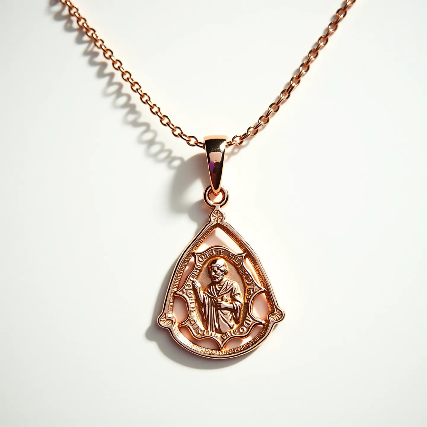 This St. Jude necklace features a gold-colored metal pendant with a detailed depiction of St. Jude at its center. The pendant is teardrop-shaped and surrounded by a frame that includes engraved words. It hangs from a fine chain, which is likely made of the same gold-colored metal, ensuring a cohesive design. The pendant is attached to the chain with a simple bail that allows it to move freely. The necklace is secured with a classic lobster clasp, providing both functionality and security. There are no gems or stones set within the pendant, emphasizing its minimalist yet elegant design.