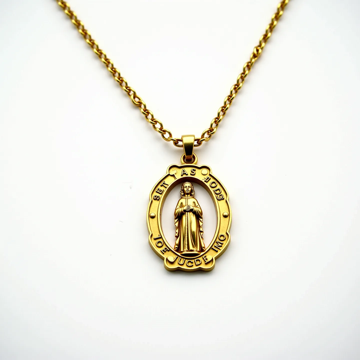 This St. Jude necklace features a lustrous gold-colored chain and pendant. The pendant depicts St. Jude encircled by an oval frame with engraved text, enhancing the intricate detailing of the saint's figure. The material is polished, giving the piece a refined and elegant appearance. No gems or stones are set within the design, keeping the focus on the metalwork. The chain is linked with a simple clasp that provides easy attachment, completing the understated yet meaningful piece.