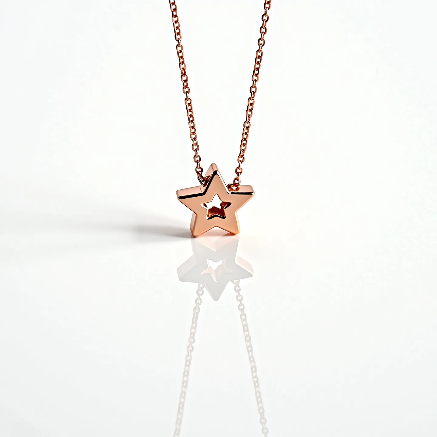 This star necklace features a polished metal star pendant with an open center design, suspended from a delicate chain that suggests a rose gold or copper finish. The star has clean, symmetrical edges, showcasing a minimalist style. The chain appears to be composed of small, interconnected links, providing a subtle yet elegant attachment that complements the pendant's simplicity. There is no indication of any gemstones or additional decorative elements on the pendant, maintaining a sleek and modern aesthetic. The necklace likely includes a standard clasp mechanism at the back for secure fastening.