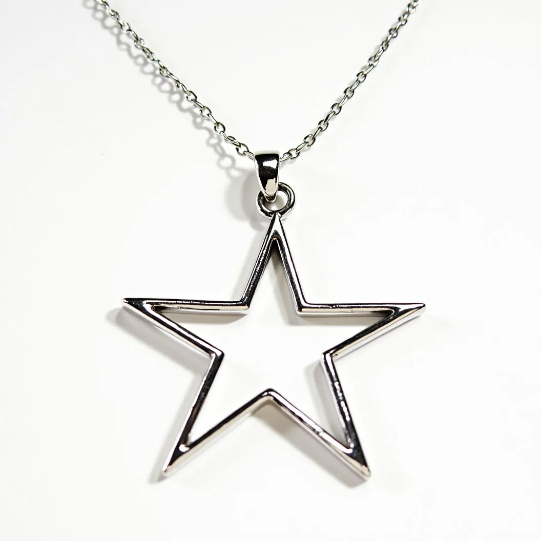 This star necklace features a sleek, open star pendant crafted from a polished metal, giving it a shiny and elegant appearance. The star is hollow and outlined with clean lines, enhancing its modern aesthetic. The pendant is attached to a delicate chain through a simple loop bail, allowing it to hang freely. The chain appears to be made of a similar metal, possibly stainless steel or silver, complementing the pendant's minimalist design. The necklace is equipped with a standard clasp mechanism for secure attachment, making it both stylish and functional.