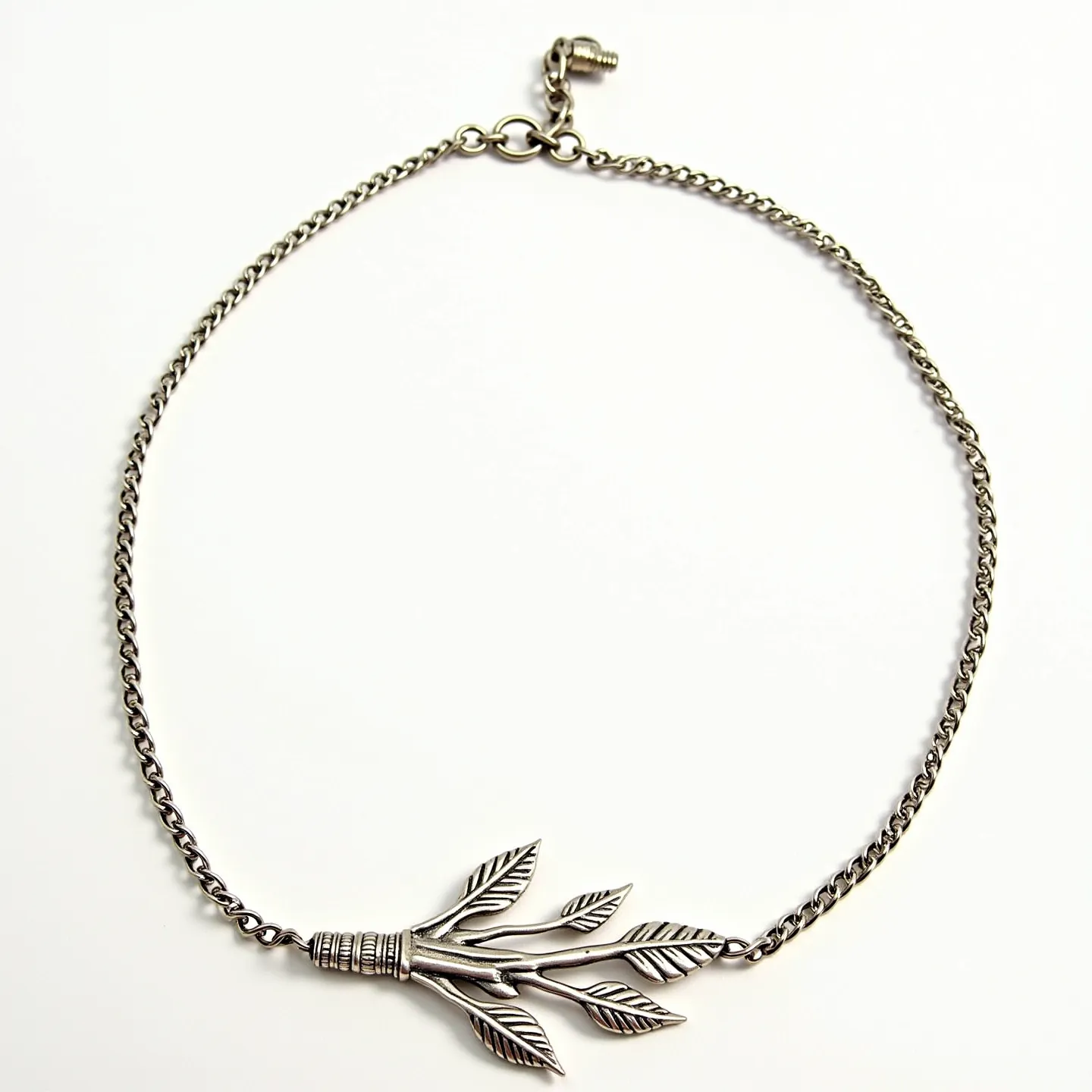 This sterling silver necklace features a decorative pendant design resembling a bundle of leafy branches, detailed with etched lines to accentuate the leaf patterns. The pendant hangs from a simple, elegant chain, which is composed of interconnected, small round links contributing to its delicate appearance. The chain is secured with a lobster claw clasp, ensuring a reliable and easy closure. The overall design exudes a natural and organic aesthetic, enhanced by the intricate detailing in the pendant.