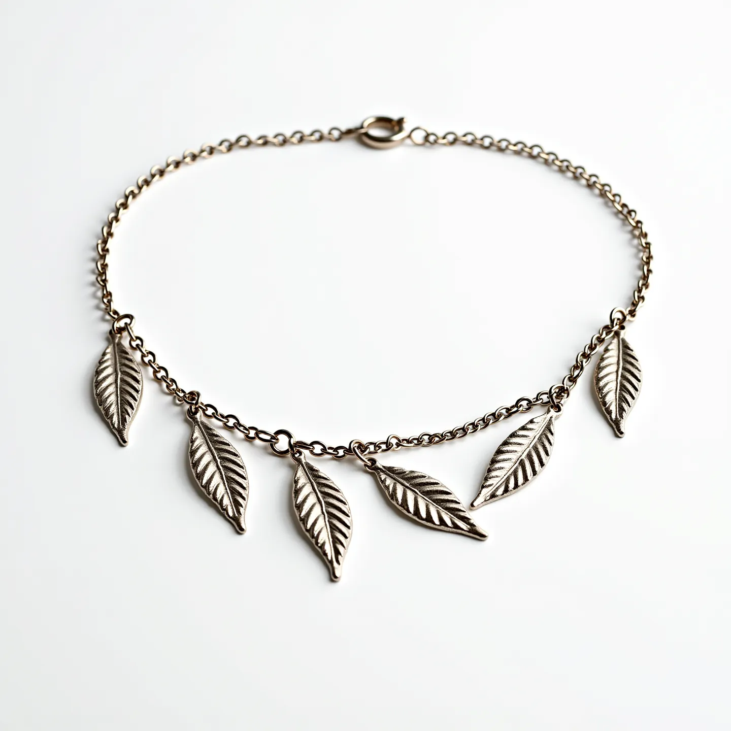 This sterling silver necklace features a delicate chain adorned with six intricately designed leaf-shaped charms, each showcasing detailed vein patterns. The charms are evenly spaced along the chain, adding an elegant and naturalistic touch to the piece. The necklace is fastened with a spring ring clasp, providing a secure and classic closure. The overall design combines simplicity with a touch of nature-inspired artistry, making it a versatile accessory for various occasions.