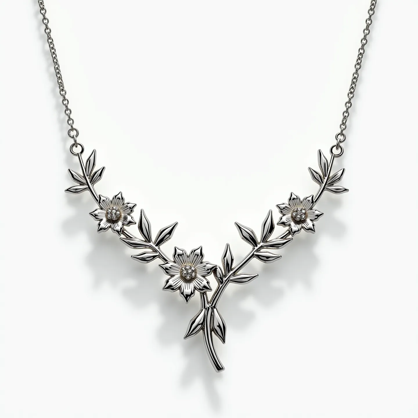 This sterling silver necklace features an elegant design of intertwined branches adorned with intricately detailed flowers and leaves. The flowers have a central bead-like detail that adds texture and dimension to the piece. The necklace is connected by a delicate chain that secures with a simple loop clasp, allowing for easy fastening. The craftsmanship showcases both the sheen of sterling silver and the artistry of its floral motifs.