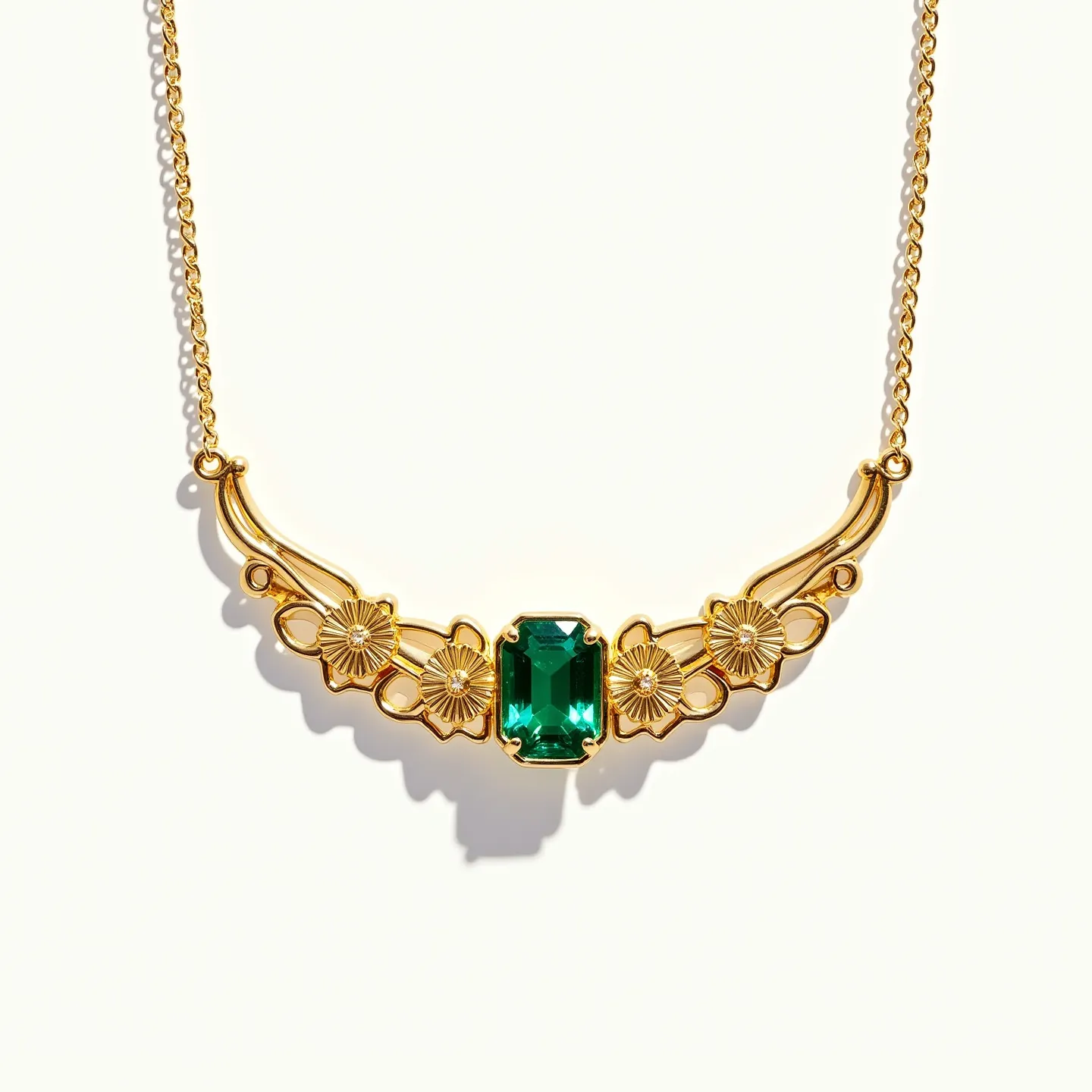 This stone necklace features a central rectangular-cut green gemstone set in a gold-tone setting, framed by a series of intricately designed floral motifs on either side. The gold-tone metal, possibly gold-plated or brass, enhances the brilliant green hue of the stone, creating a vibrant contrast. The floral design elements include detailed petals that provide an elegant and vintage-inspired aesthetic. The necklace is attached to a fine chain, likely matching the setting material, with a standard clasp for secure wear. The combination of the rich green stone and the ornate gold-tone floral elements makes this necklace a striking and sophisticated piece.