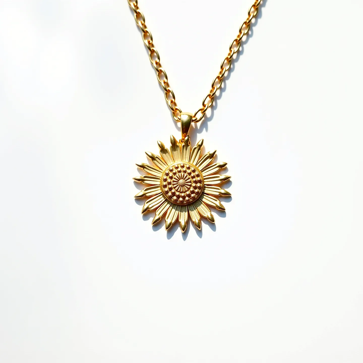 This sunflower necklace features a beautifully crafted pendant, designed to resemble a sunflower in full bloom. The pendant appears to be made of a gold-colored metal, with intricate detailing that captures the texture of sunflower petals and the central disc florets. The chain is a matching gold tone, designed with oval links that create a harmonious and elegant look. The pendant is securely attached to the chain with a simple loop that complements the overall design. There are no additional stones or gems embedded in this piece, allowing the craftsmanship of the sunflower design to stand out prominently.