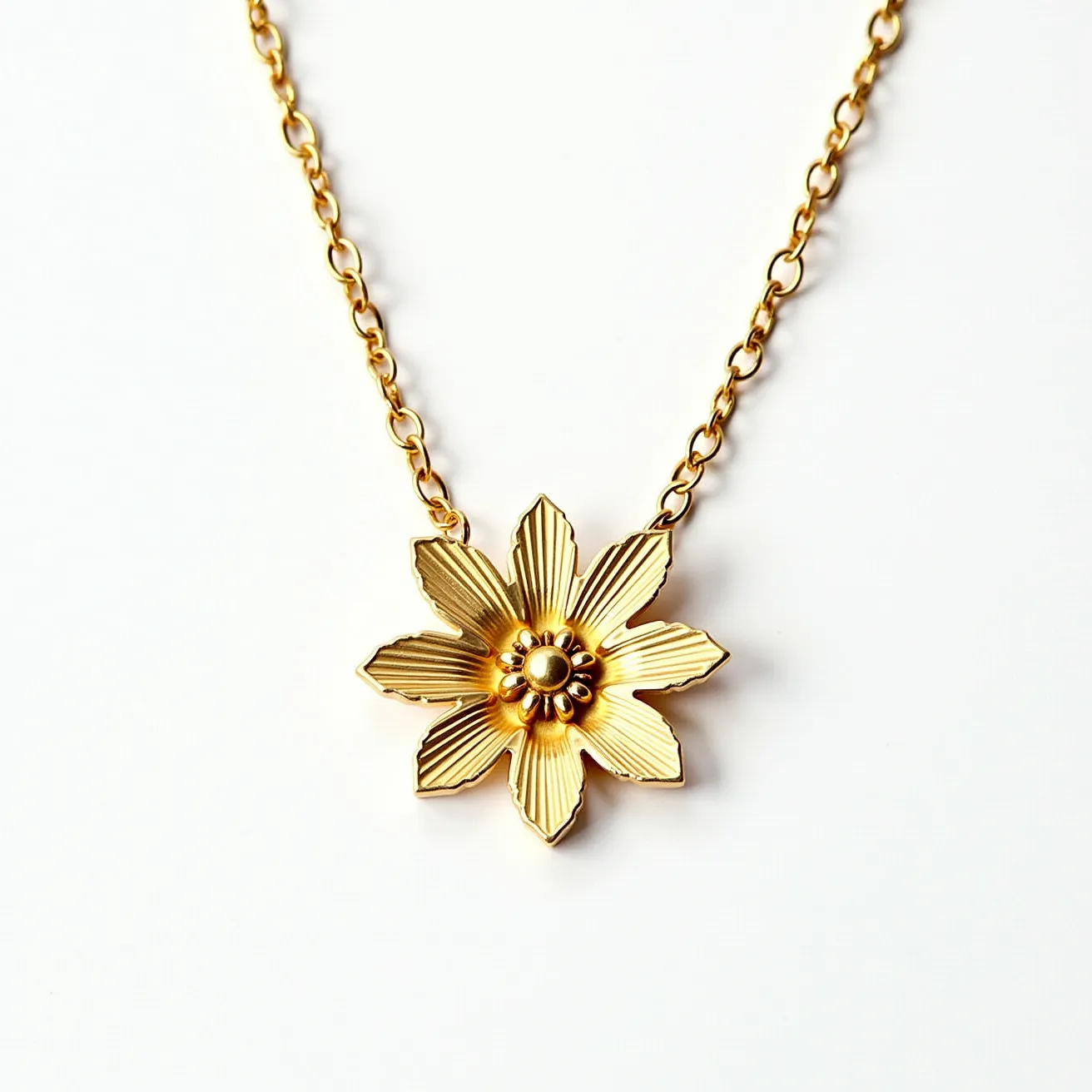 This sunflower necklace features a beautifully crafted floral pendant with six textured petals surrounding a central circular detail. The necklace appears to be made of a gold-tone metal, giving it a warm and elegant look. The pendant is intricately designed to mimic the natural structure of a sunflower, with a smooth, polished finish for added refinement. The necklace is attached to a matching gold-tone chain with a simple link design, enhancing its overall appeal and providing a delicate balance between the pendant and chain.