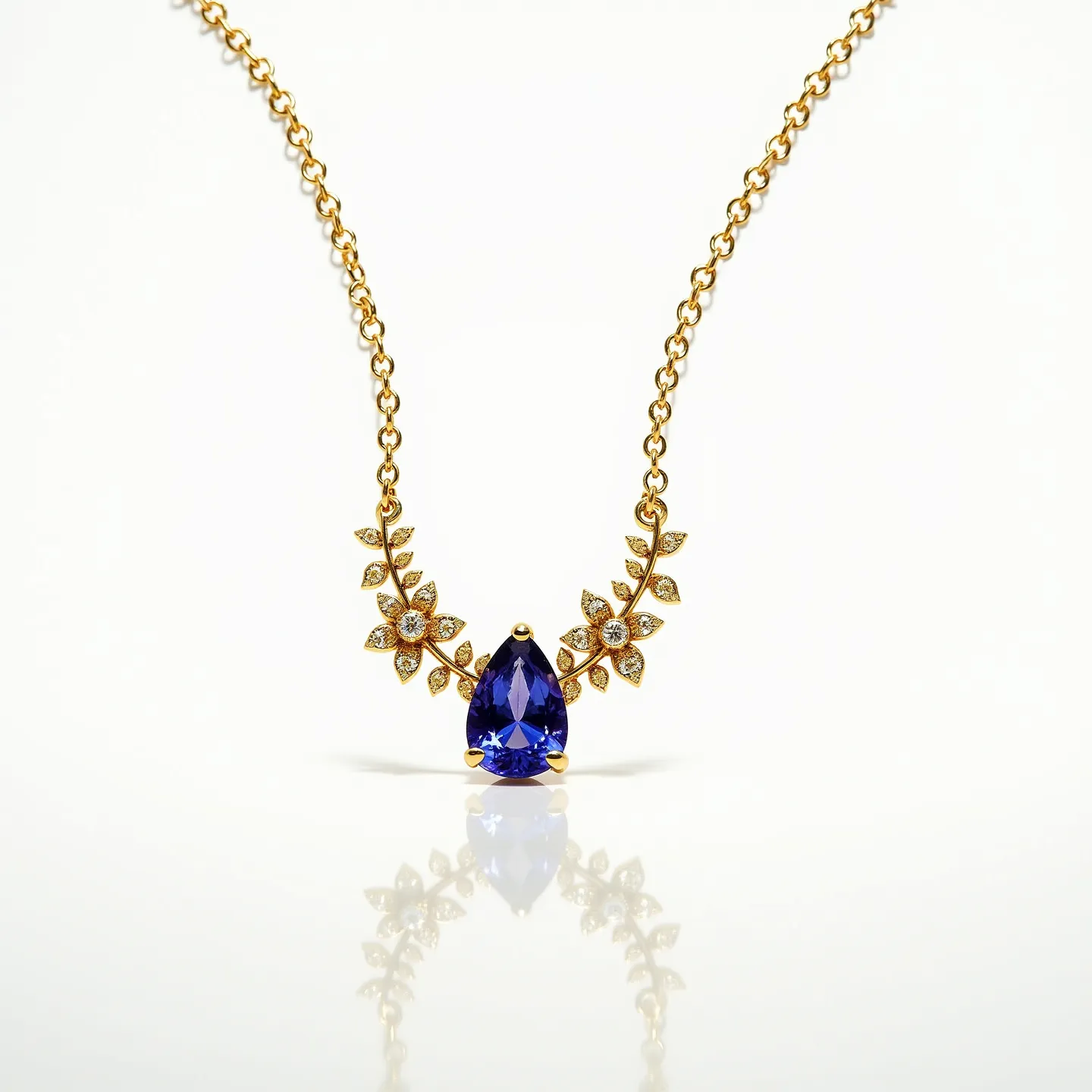 This tanzanite necklace features a centerpiece of a pear-cut tanzanite gemstone, known for its vibrant blue-violet color. The stone is set in a gold prong setting, which securely holds the gem while enhancing its beauty with a touch of elegance. Surrounding the central stone are intricate floral accents crafted from gold, each adorned with small, sparkling diamonds in prong settings, adding a touch of luxury and sophistication. The chain is made of gold links, which seamlessly connect to the decorative floral motif, likely with a clasp at the back for secure fastening.