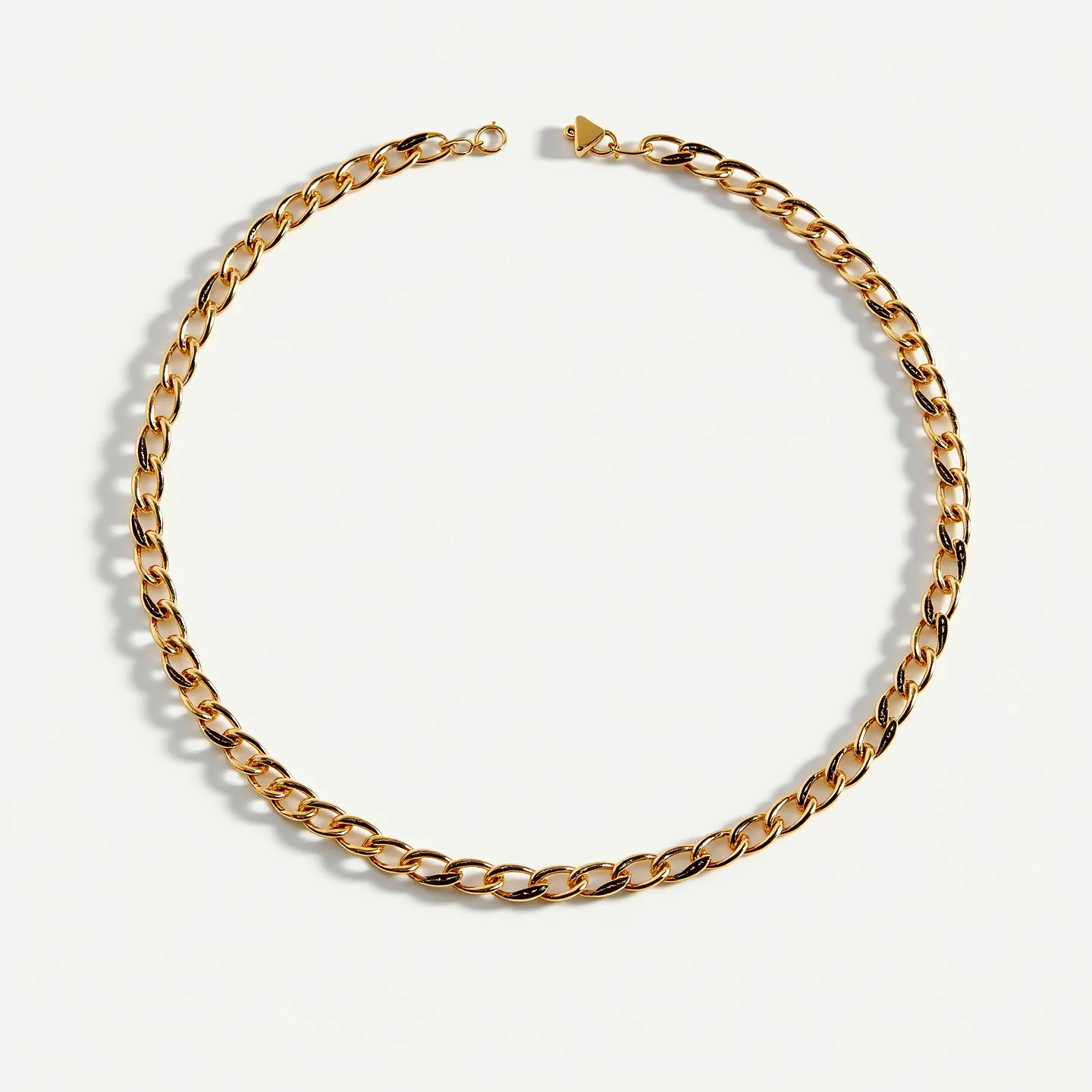 This thick chain necklace features a series of interlocking links crafted from a polished metal with a gold-like finish. The smooth, uniform links create a classic curb chain design, known for its timeless appeal and durability. This piece is noted for its heavy, substantial appearance, indicating the use of high-quality metalwork. The necklace is equipped with a discreet and secure clasp that blends seamlessly with the overall design, ensuring functionality and ease of wear. The necklace does not incorporate any additional gems or stones, allowing the metal itself to be the focal point of this elegant piece.