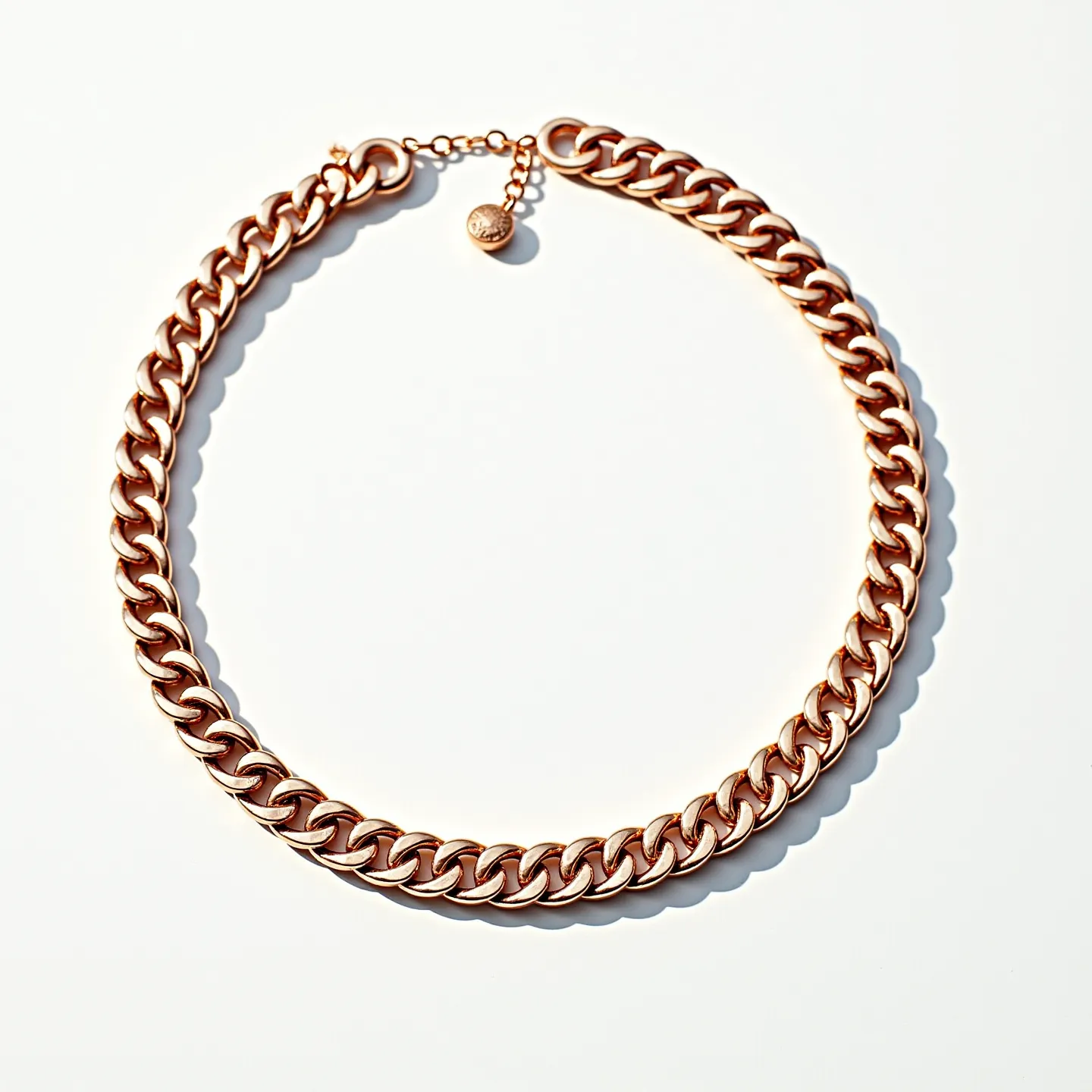 This thick chain necklace features interlocking, closely linked curb chains, crafted from a material that appears to be rose gold, providing a warm and luxurious finish. The necklace is equipped with a simple yet secure lobster claw clasp, ensuring seamless attachment and ease of wear. Additionally, there is an adjustable extension chain with a small round charm at the end, allowing for customization of the necklace's length. The design is bold yet elegant, suitable for a statement piece that complements various styles and occasions.