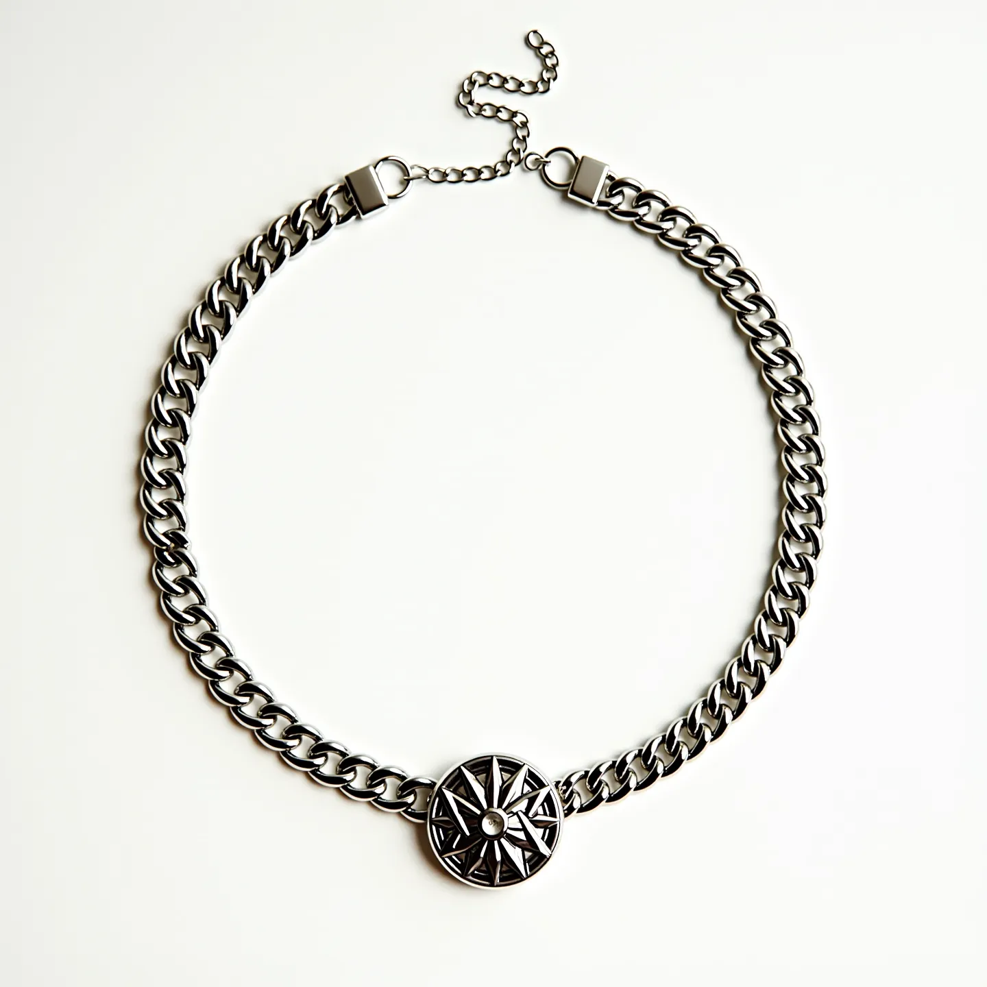 This thick chain necklace features a robust, intertwined link design made of a shiny metal, likely stainless steel or silver for its reflective qualities. The centerpiece is a round medallion with a geometric pattern reminiscent of a compass, highlighting a small, centrally-placed gemstone with a clear, round-cut appearance. The gem is set within a bezel that secures it seamlessly and adds to the symmetrical allure of the design. The necklace is fastened with a lobster clasp, accompanied by an adjustable chain that ensures versatile wearability. The craftsmanship displays a blend of boldness and intricate detailing, making it a striking accessory.