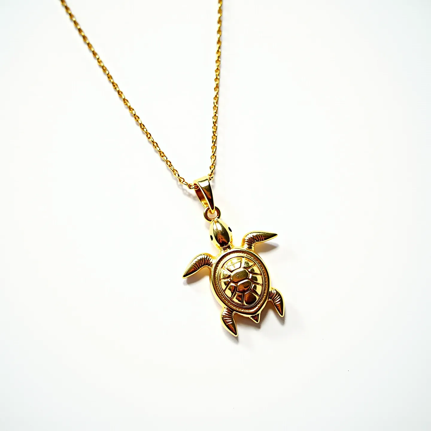 This turtle necklace features a detailed turtle pendant crafted from metal with a golden finish, giving it a rich, lustrous appearance. The body of the turtle highlights intricately designed segments that resemble a turtle's shell. It is suspended from a delicate chain, also with a golden hue, which complements the pendant. The pendant is attached securely with a bail that allows for smooth movement along the chain. The chain itself appears to have a simple clasp mechanism, making it easy to wear. The overall design exudes a sense of elegance and attention to detail.