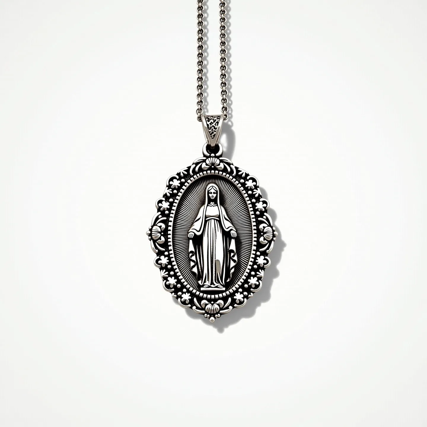 This virgin Mary necklace features an intricately designed pendant, likely made from a polished silver or silver-tone metal, showcasing the image of the Virgin Mary surrounded by ornate floral and scroll patterns in a raised relief. The pendant is an oval shape, adding an elegant symmetry to the design. It hangs from a delicate chain with a simple yet secure lobster clasp, enhancing the necklace's overall functionality and ease of wear. The detailed craftsmanship highlights both the religious symbolism and artistic elegance of the piece.