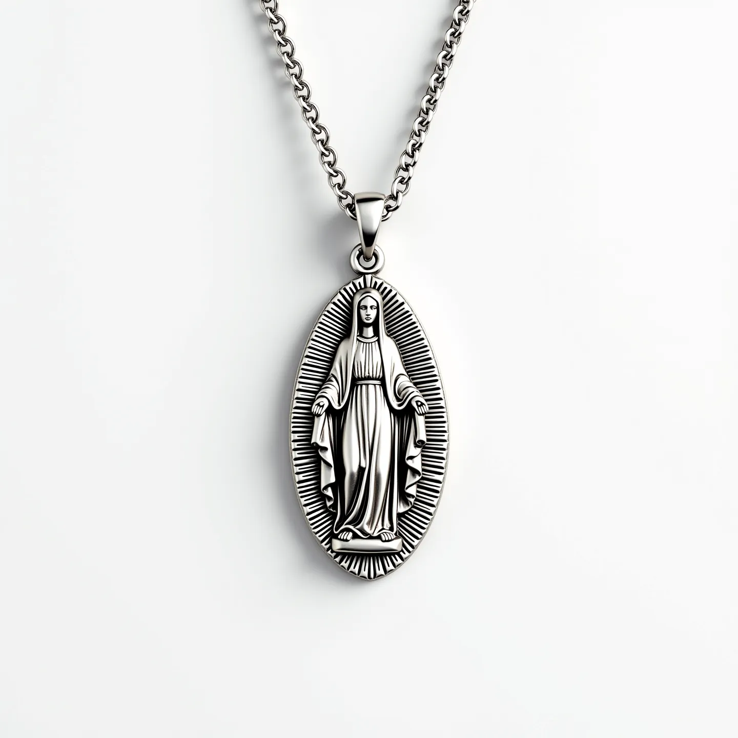 This Virgin Mary necklace features an intricate oval pendant crafted from silver-toned metal, depicting the Virgin Mary in a detailed, three-dimensional relief. The pendant is designed with a radiating pattern around the central figure, emphasizing a sense of divinity and reverence. It hangs from a sturdy, matching chain with a classic cable link pattern, ensuring both durability and a timeless aesthetic. The necklace is secured with a simple, yet reliable, lobster clasp, allowing for easy attachment and removal. The overall design combines elegance with a deep sense of spirituality, making it a meaningful accessory.