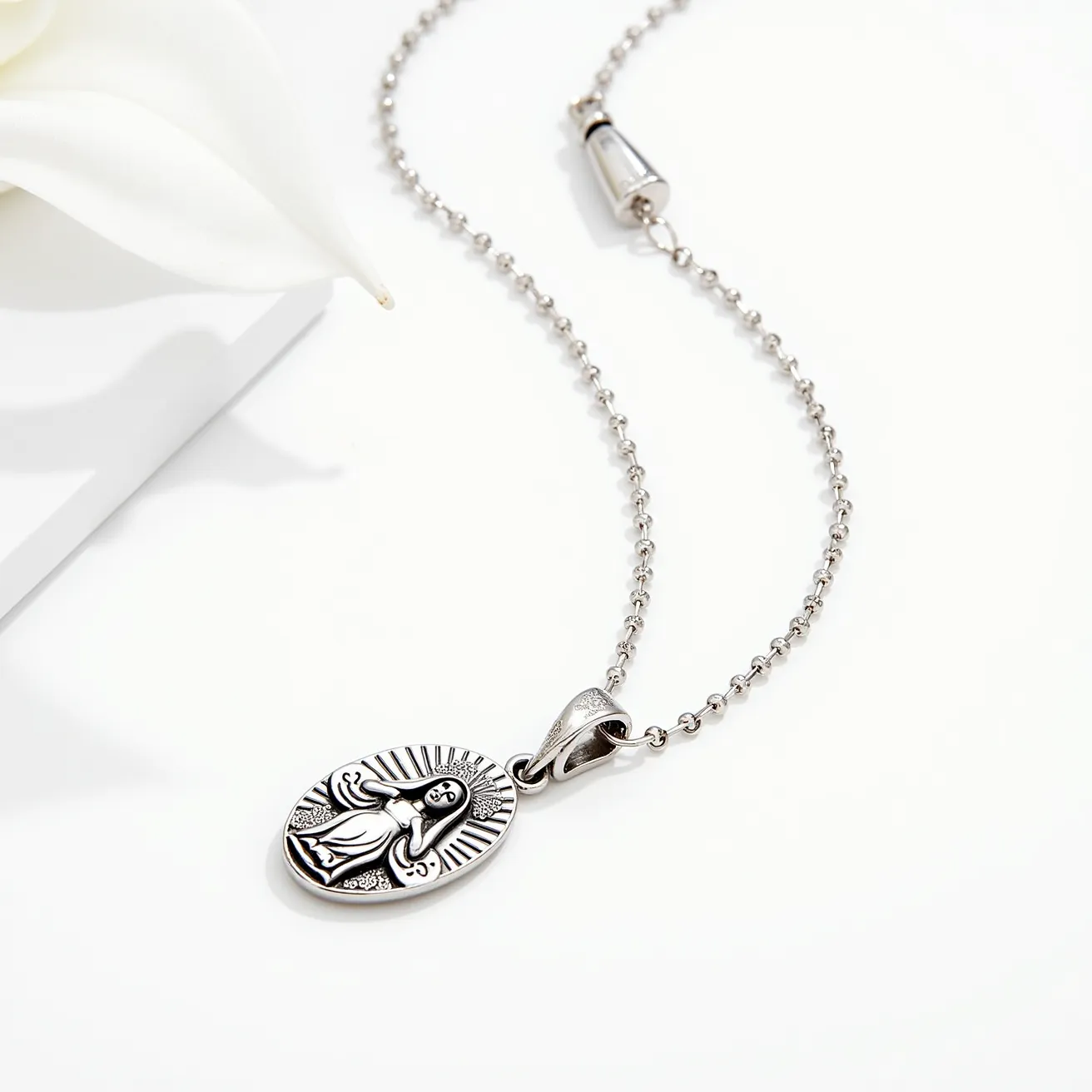 This Virgin Mary necklace features a finely crafted pendant depicting the Virgin Mary in an oval shape with intricate detailing. The pendant appears to be made of a polished silver-tone metal, reflecting light elegantly. The chain consists of small, rounded links that complement the pendant's size and design. The necklace is secured with a cone-shaped clasp, which adds a subtle decorative element while ensuring it stays fastened. The simplicity of the design emphasizes the craftsmanship of the pendant, making it a tasteful piece of jewelry.