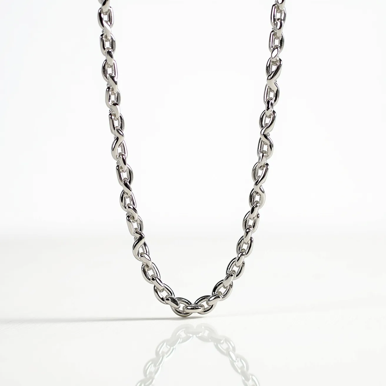 This white gold chain features a series of polished, interlocking links that create a sleek and continuous design. The links are uniformly crafted, highlighting the luxurious sheen of the white gold material. There are no visible gemstones, emphasizing the chain's understated elegance. The chain likely includes a secure clasp mechanism in its design for easy attachment and wearability, though it is not visible in the section shown. The overall craftsmanship illustrates a timeless piece suitable for various occasions.