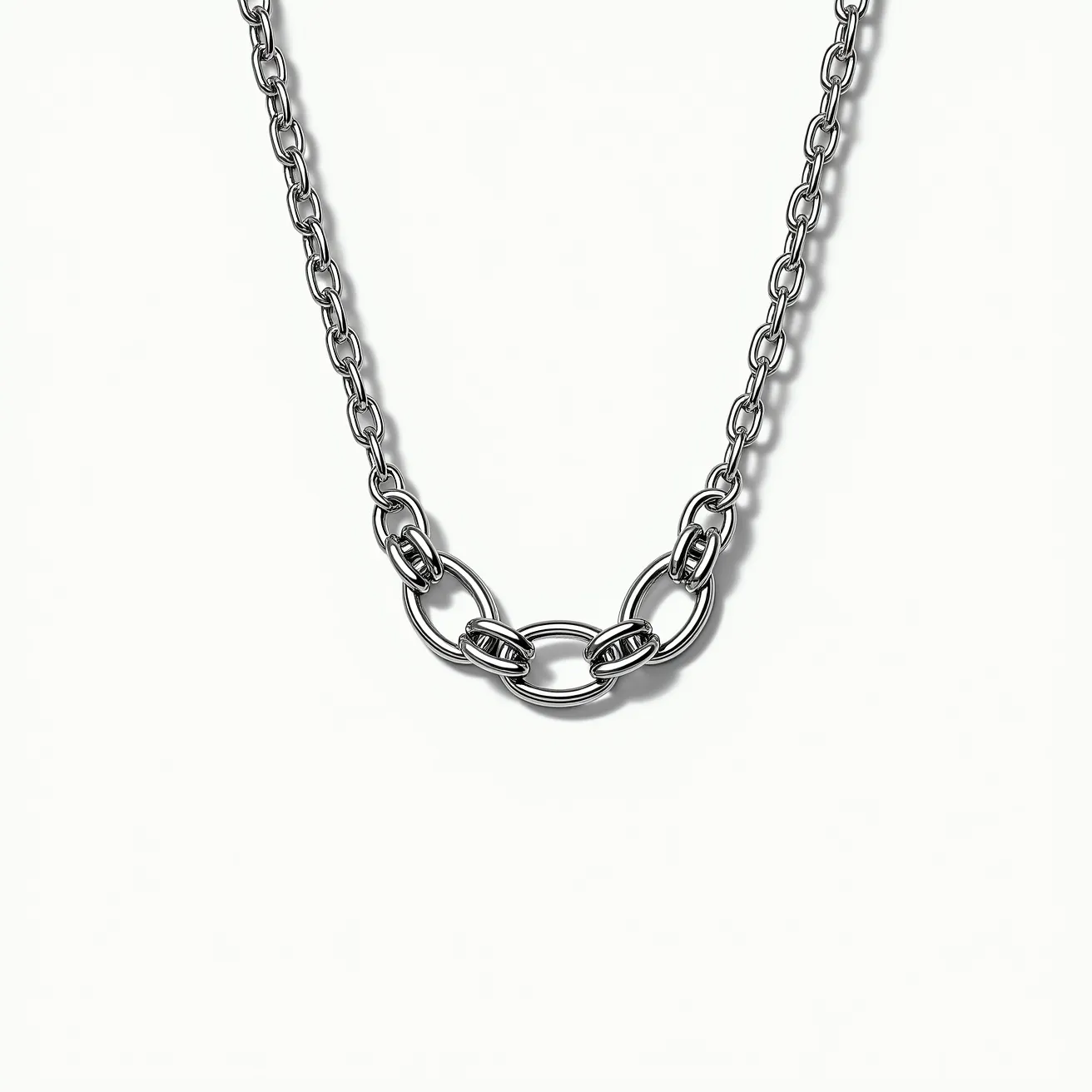 This white gold necklace features a chain design composed of interlocking links, providing a sleek and polished appearance. At its center, larger oval links are intricately entwined with smaller, rounder links, creating a focal point that adds visual interest to the piece. The necklace's material, white gold, gives it a luxurious sheen and durability, making it a timeless accessory. There are no visible gemstones embedded in the design, focusing on the elegance of the metalwork itself. The clasp, although not detailed here, generally complements the design by ensuring a secure and seamless wearability.