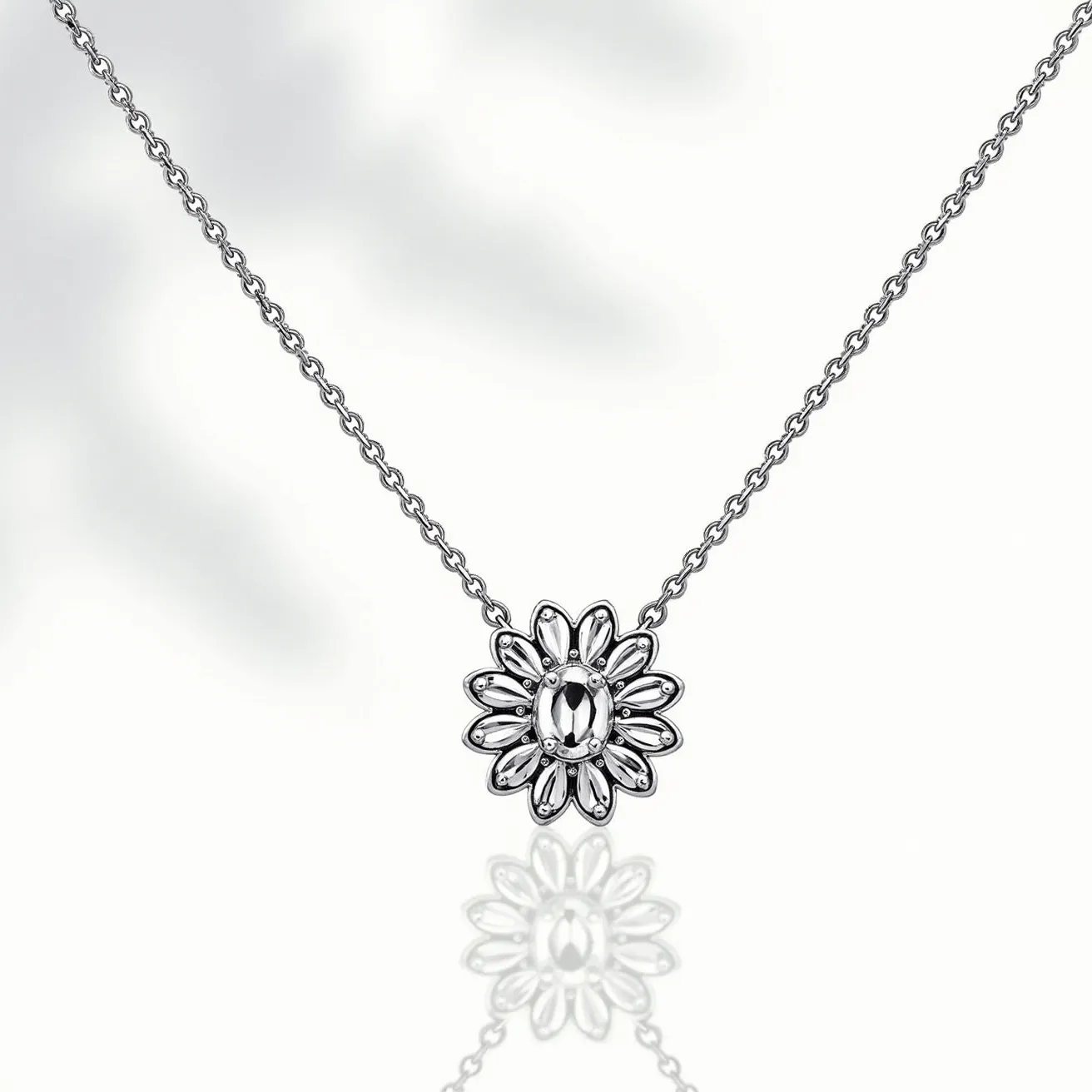 This white sapphire necklace features a delicate, flower-shaped pendant with meticulously arranged oval white sapphires forming the petals. The centerpiece is an oval-cut white sapphire, elegantly set within a polished metal frame that highlights its clarity and brilliance. Each sapphire is securely held in place by prongs, ensuring durability while maximizing light reflection to enhance its sparkle. The necklace is crafted from a fine chain, likely made from a high-quality metal such as sterling silver or white gold, contributing to its overall elegance and sophistication. A sleek, simple clasp provides a secure and seamless closure, ensuring the necklace can be worn comfortably.