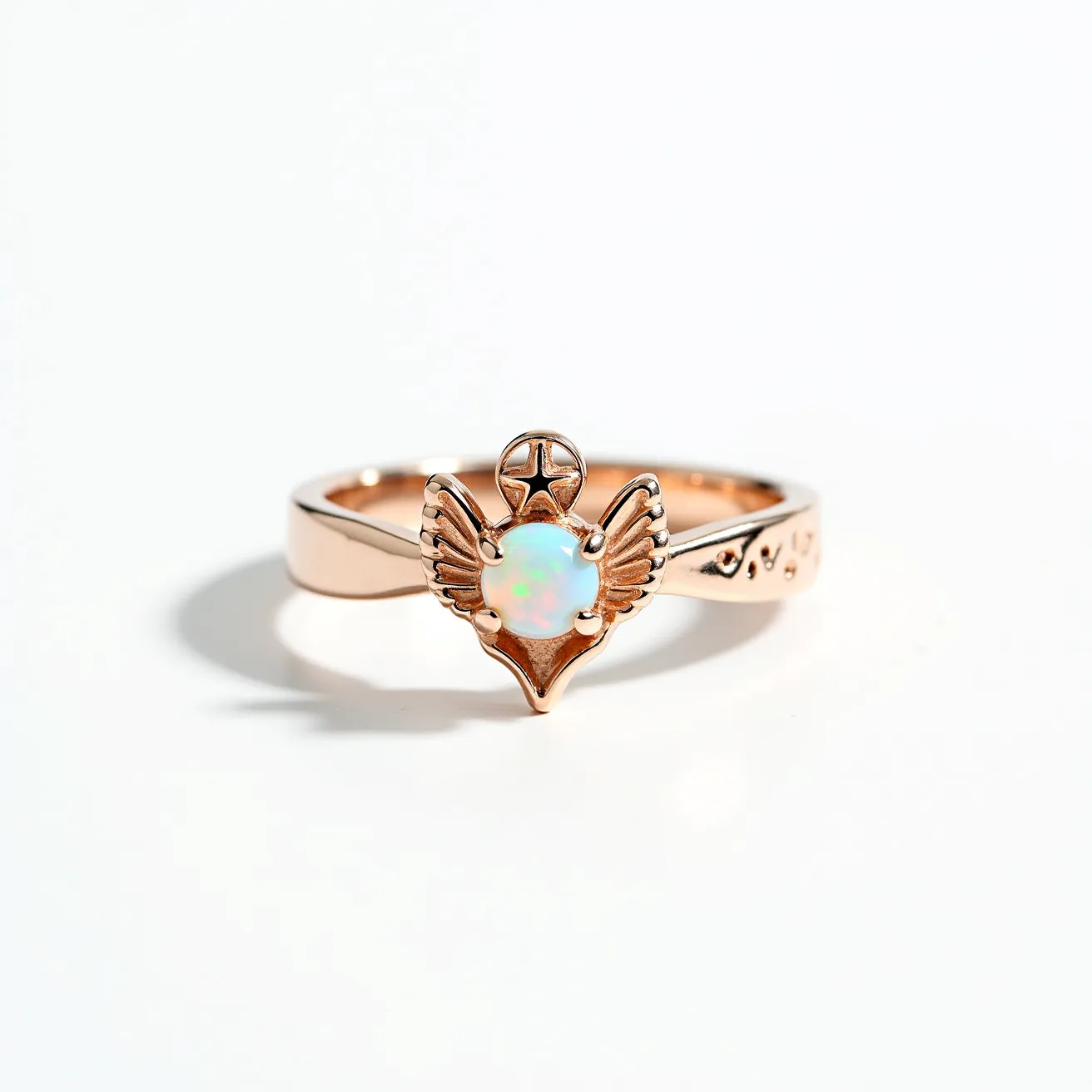 This angel ring features a beautifully crafted rose gold band adorned with intricate details. At the center, there is an opal gemstone, known for its iridescent play of colors, which is set securely in a bezel setting. The opal is encased with a winged design that adds an ethereal and spiritual touch to the piece, crowned with a star symbol above it. The band itself is sleek, designed for a comfortable fit, with small embellishments on the sides that complement the central motif, enhancing the overall elegance and delicate craftsmanship of the ring.