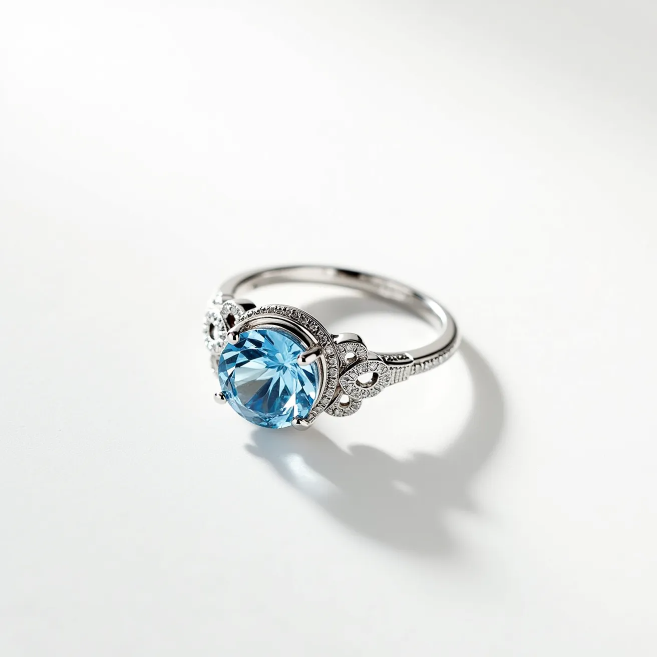 This aquamarine ring features a dazzling round-cut aquamarine gemstone at its center, showcasing a vivid blue hue that is both captivating and elegant. The stone is secured in a prong setting, allowing maximum light to enhance its brilliance. Surrounding the aquamarine, the ring is adorned with delicate floral motifs embellished with small, shimmering diamonds, adding an extra layer of sophistication. The band appears to be made of a lustrous white metal, possibly platinum or white gold, which complements the cool tones of the aquamarine. Its intricate design combines vintage and modern elements, making it a timeless and exquisite piece of jewelry.