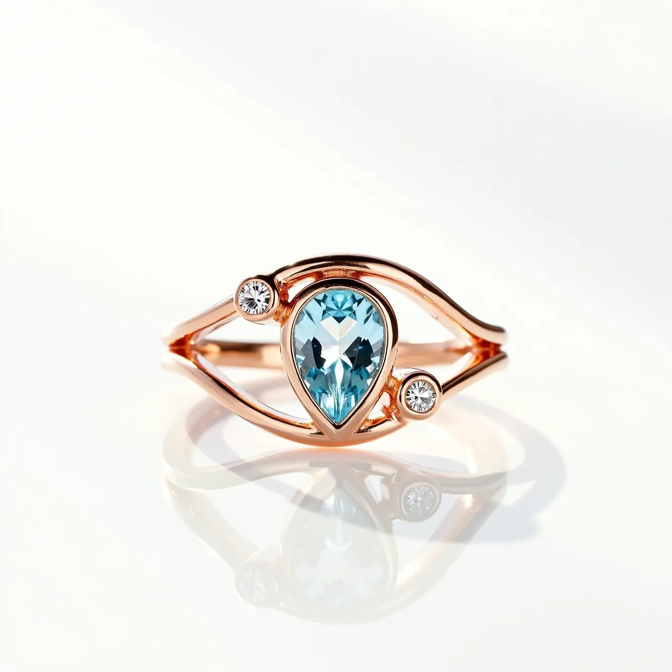 This aquamarine ring features a stunning pear-cut aquamarine stone, set in a delicate rose gold band. The central aquamarine is elegantly complemented by two round brilliant-cut diamonds, positioned on either side in a bezel setting. The design includes sleek lines that enhance the beauty of the stones, adding a modern flair to the overall aesthetic. The combination of aquamarine with the warmth of rose gold and the sparkle of diamonds creates a harmonious and eye-catching piece.