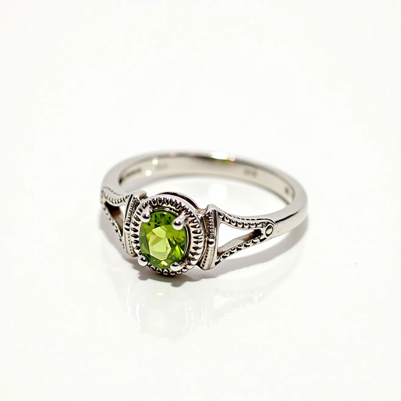 This August birthstone ring features a vibrant peridot gemstone, which is expertly cut in a round shape, showcasing its vivid green color. The peridot is set in a decorative prong setting that enhances its sparkle and draws attention to the stone. The band is intricately designed with detailed metalwork, likely made of sterling silver, contributing to an elegant and sophisticated appearance. The detailed beading along the setting adds an element of vintage charm, while the split shank design provides a unique structural flair. The craftsmanship highlights the beauty and significance of the birthstone, making it a perfect choice for August celebrants.