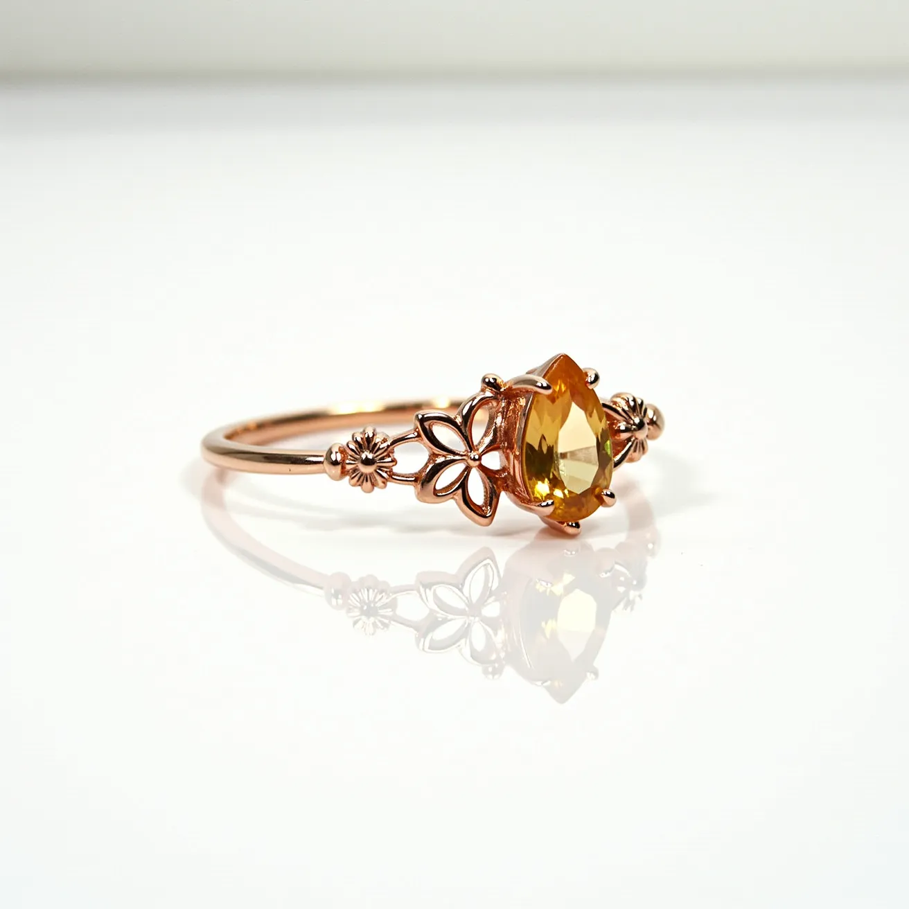 This bee ring is crafted from a rose gold material, featuring a soft and elegant design. At its center, it showcases a pear-shaped yellow gemstone, held securely in place by a prong setting that accentuates the gem's facets and clarity. The ring's band is adorned with intricate bee and flower motifs, adding a whimsical and nature-inspired charm to the piece. The overall design is delicate and well-balanced, perfect for those who appreciate both elegance and whimsical style in their jewelry collection.