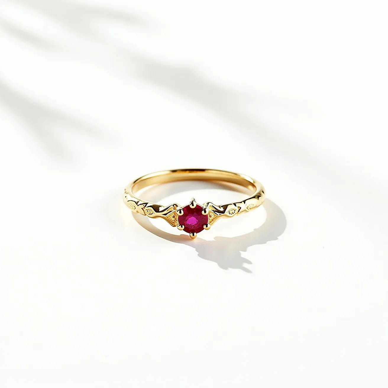 This birthstone ring features a delicate design crafted from gold, showcasing a central round-cut ruby set in a prong setting. The band is adorned with intricate detailing, adding a touch of elegance to the overall design. The ruby, known as the birthstone for July, is prominently displayed, capturing attention with its vibrant red hue. The prong setting securely holds the gemstone in place, ensuring it is both stylish and stable.