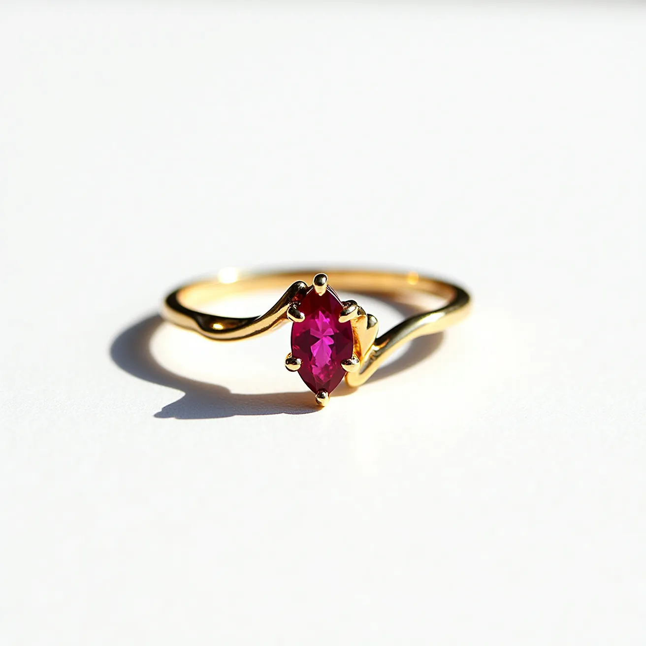 This birthstone ring features a marquise-cut gemstone with a vivid pink hue, possibly a ruby or garnet, which is securely held in place by a prong setting. The band of the ring is crafted from gold, exhibiting a smooth, polished finish that complements the vibrant stone. The gold band subtly twists as it approaches the gemstone, adding a touch of elegance and sophistication to the design. The overall craftsmanship highlights a balance between the boldness of the gemstone and the refined simplicity of the gold band.