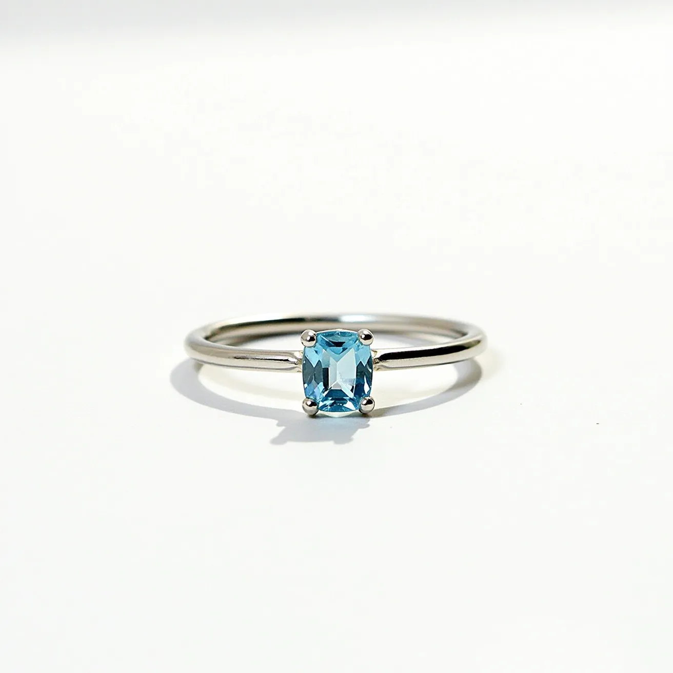 This birthstone stackable ring features a sleek and elegant design with a polished silver band that enhances its understated beauty. At its center, a stunning rectangular-cut blue gemstone is meticulously set in a four-prong setting, ensuring both security and optimum light reflection to maximize its brilliance. The simplicity of the band allows for easy stacking with other rings, making it a versatile piece for any jewelry collection. The minimalist design highlights the vibrancy of the birthstone, making it a subtle yet sophisticated statement piece.