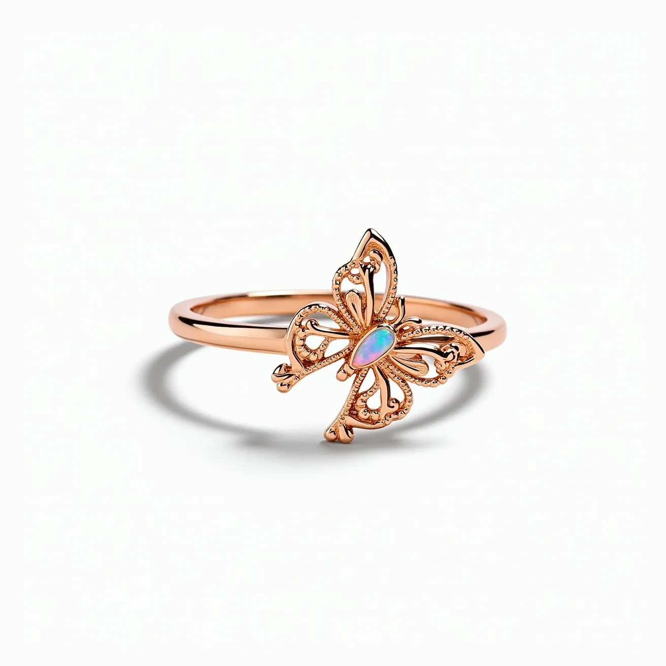 This butterfly ring features a delicate and intricate butterfly design crafted in rose gold. The wings are elegantly shaped with openwork detailing, lending a refined texture to the piece. At the center of the butterfly, there is an opal gemstone, cut in an oval shape, exuding a captivating play of colors. The opal is securely set within a bezel setting, providing both elegance and protection. The band is slender and smooth, emphasizing the graceful design of the butterfly, with no visible clasps or attachments, making it a seamless and stylish accessory.