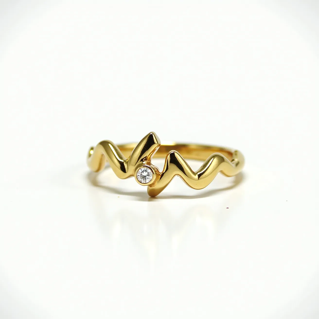 This chevron ring features a sleek, zigzag pattern crafted from polished gold. At the center peak of the design is a single round-cut gemstone, likely a diamond, set in a bezel setting that enhances its sparkle while offering a secure hold. The absence of a traditional clasp emphasizes the ring's continuous wave-like design, which contours elegantly around the finger. The minimalist aesthetic of this piece is accentuated by the contrast between the lustrous gold and the brilliance of the gemstone, offering both timelessness and modern appeal.