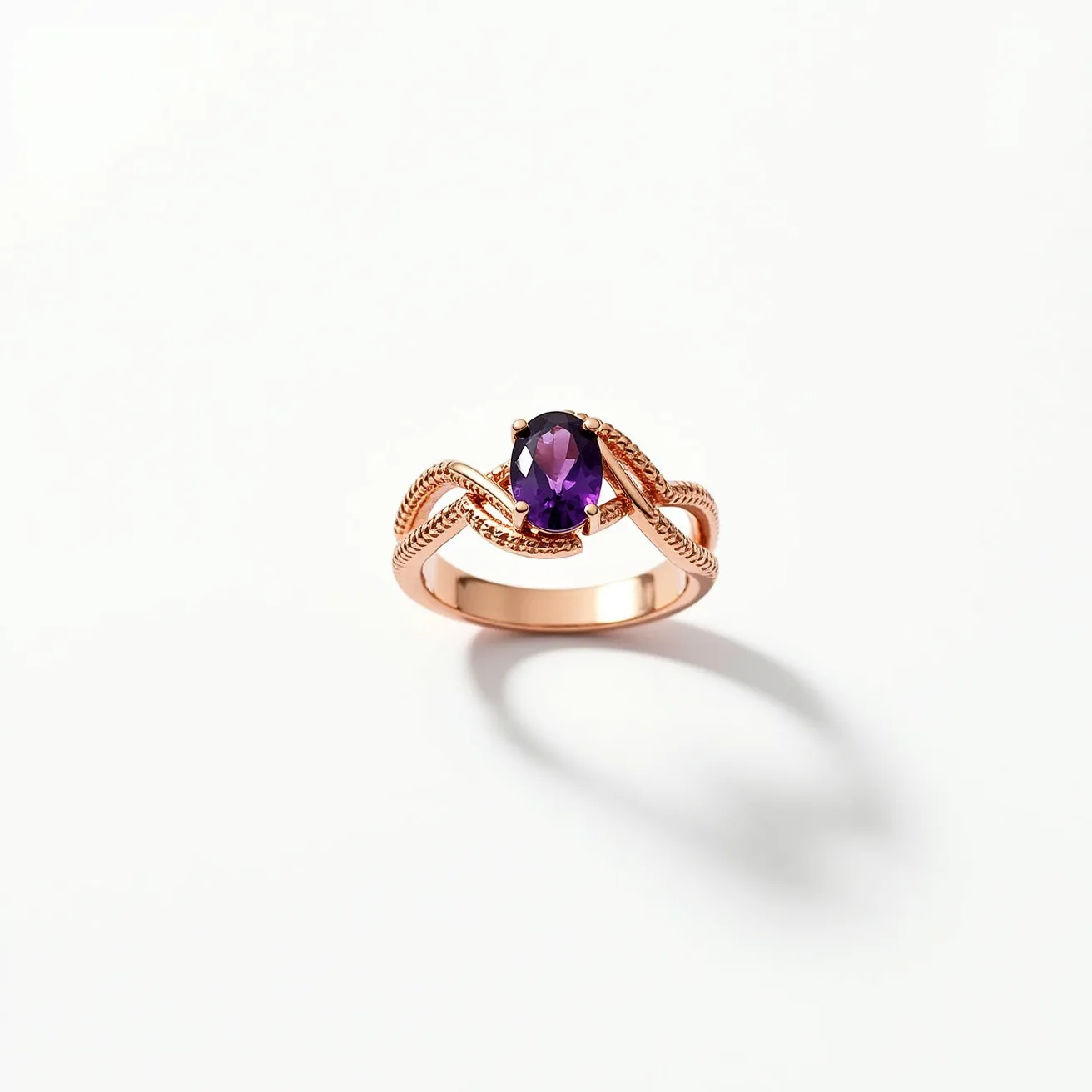 This chevron ring features a sophisticated design with a rose gold band, showcasing intricate braided detailing for added texture. At its center, the ring proudly displays an oval-cut amethyst set within a secure prong setting. The vibrant purple hue of the amethyst contrasts beautifully against the warm tones of the rose gold, enhancing its elegance and appeal. The thoughtful craftsmanship amplifies the overall aesthetic, making it a standout piece.