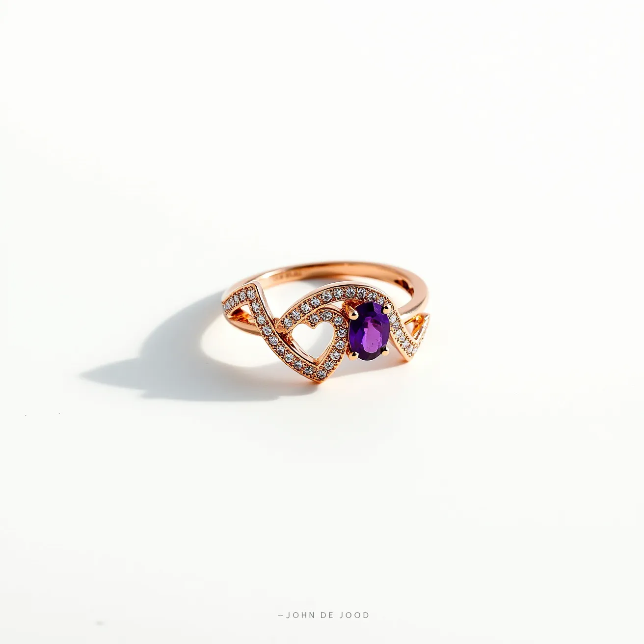 This chevron ring features a band made from what appears to be rose gold, elegantly formed into a chevron shape. The ring is adorned with small, clear round-cut gemstones, likely diamonds or cubic zirconia, encrusted along the chevron pattern. At the center, there is a prominent oval-cut purple gemstone, possibly an amethyst, set in a four-prong setting that secures it in place. The combination of the intricate design, sparkling stones, and vibrant central gem contributes to the ring's striking and sophisticated appearance.