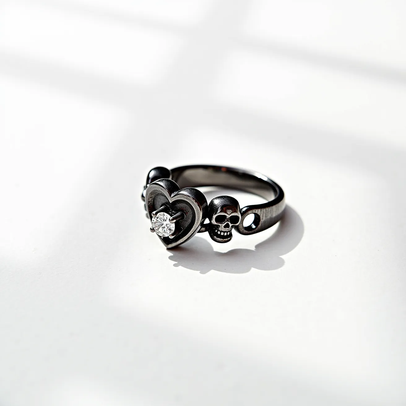 This Chrome Hearts ring features a striking design made from a dark, possibly oxidized metal, giving it a vintage and edgy appearance. The centerpiece is a heart motif, with a brilliant-cut diamond set at its core, adding a touch of elegance and sparkle. Flanking the heart are detailed skull motifs, seamlessly integrated into the band, enhancing the ring's bold and distinctive aesthetic. The overall craftsmanship reflects a unique blend of Gothic and luxurious elements often characteristic of Chrome Hearts jewelry. There are no clasps or additional attachments present.