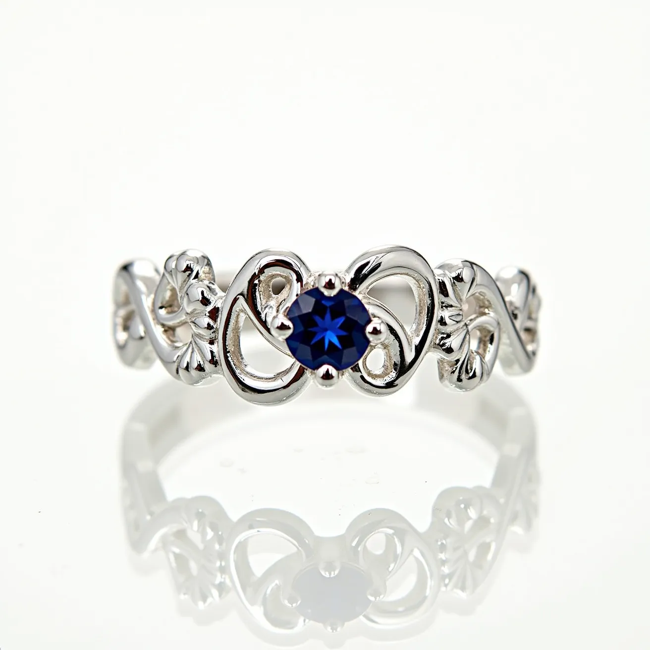 This Chrome Hearts ring showcases a sterling silver band intricately designed with interwoven patterns, characteristic of the brand's gothic and romantic style. At its center, a round-cut blue gemstone is set, held securely by a prong setting that allows light to enhance its vibrant hue. The ring's design is both bold and elegant, featuring meticulous craftsmanship evident in the detailed metalwork surrounding the gemstone. The use of high-quality materials and precise setting highlights Chrome Hearts' dedication to luxury and unique artistry in jewelry.