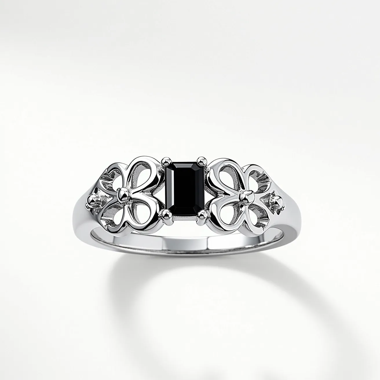 This Chrome Hearts ring features a polished metallic band, likely crafted from sterling silver or white gold. It is adorned with a central rectangular black gem, set in a four-prong setting that holds the stone securely in place. The band incorporates intricate designs, resembling floral motifs, which add a unique aesthetic appeal to the piece. These decorative elements are enhanced by their polished finish, providing a refined contrast to the central gemstone. This ring captures the luxurious and edgy design ethos characteristic of Chrome Hearts jewelry.