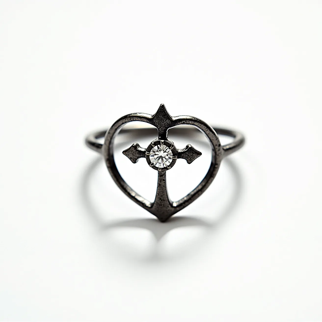 This Chrome Hearts ring is crafted from a metallic material, likely sterling silver, featuring an intricate heart design formed by sleek, stylized lines. At the center of the heart is a cross motif that securely holds a single, round-cut gemstone, possibly a diamond or a comparable clear stone, set in a simple prong or bezel setting to ensure stability and accentuate its brilliance. The ring band is smooth and seamlessly integrated with the heart and cross design, with no visible clasps or attachments, providing a uniform and polished appearance that exemplifies the brand's unique blend of gothic and contemporary aesthetics.