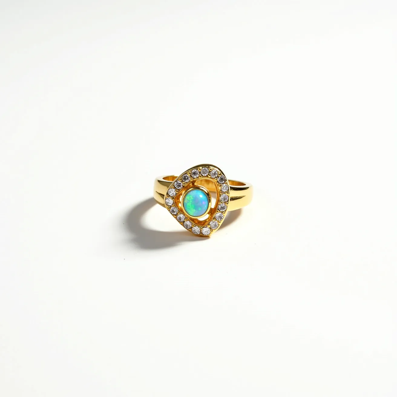 This cocktail ring features a striking central opal stone with a captivating play of colors, set in a gold band. The opal is round-cut and is framed by a halo of small round diamonds that are securely pave-set, enhancing its brilliance and adding sparkle to the piece. The band itself is made of polished gold, which complements the vibrant hues of the opal and the shimmering clarity of the diamonds. This ring, with its combination of materials and stones, offers an elegant yet bold statement, perfect for special occasions.