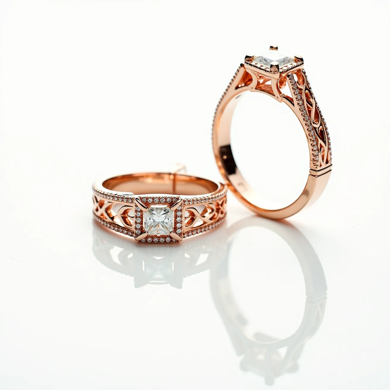 These couple rings feature a striking design crafted from rose gold, exuding a warm and elegant appeal. The rings showcase a prominent square-cut gemstone, likely a diamond, set securely in a prong setting that highlights its brilliance. The wider band has intricate lattice work along the sides, adorned with numerous small round-cut stones that add extra sparkle. The design combines both intricate detailing and a classic setting, making the rings both modern and timeless in their aesthetic.