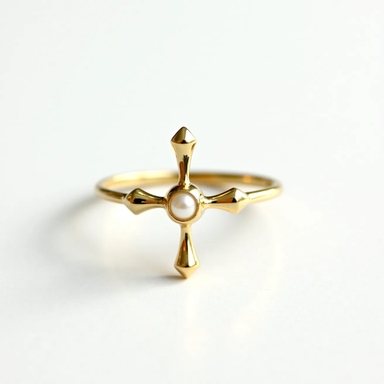 This cross ring features a delicate gold band with a prominent cross design at the center. The cross is adorned with a single pearl, round in shape and smoothly polished, set centrally. The ends of the cross have pointed, geometric tips that add a touch of sophistication to the overall design. The gold material provides a classic and elegant appearance, enhancing the luster of the pearl. The ring structure is seamless, suggesting a comfortable fit without any visible clasps or attachments.