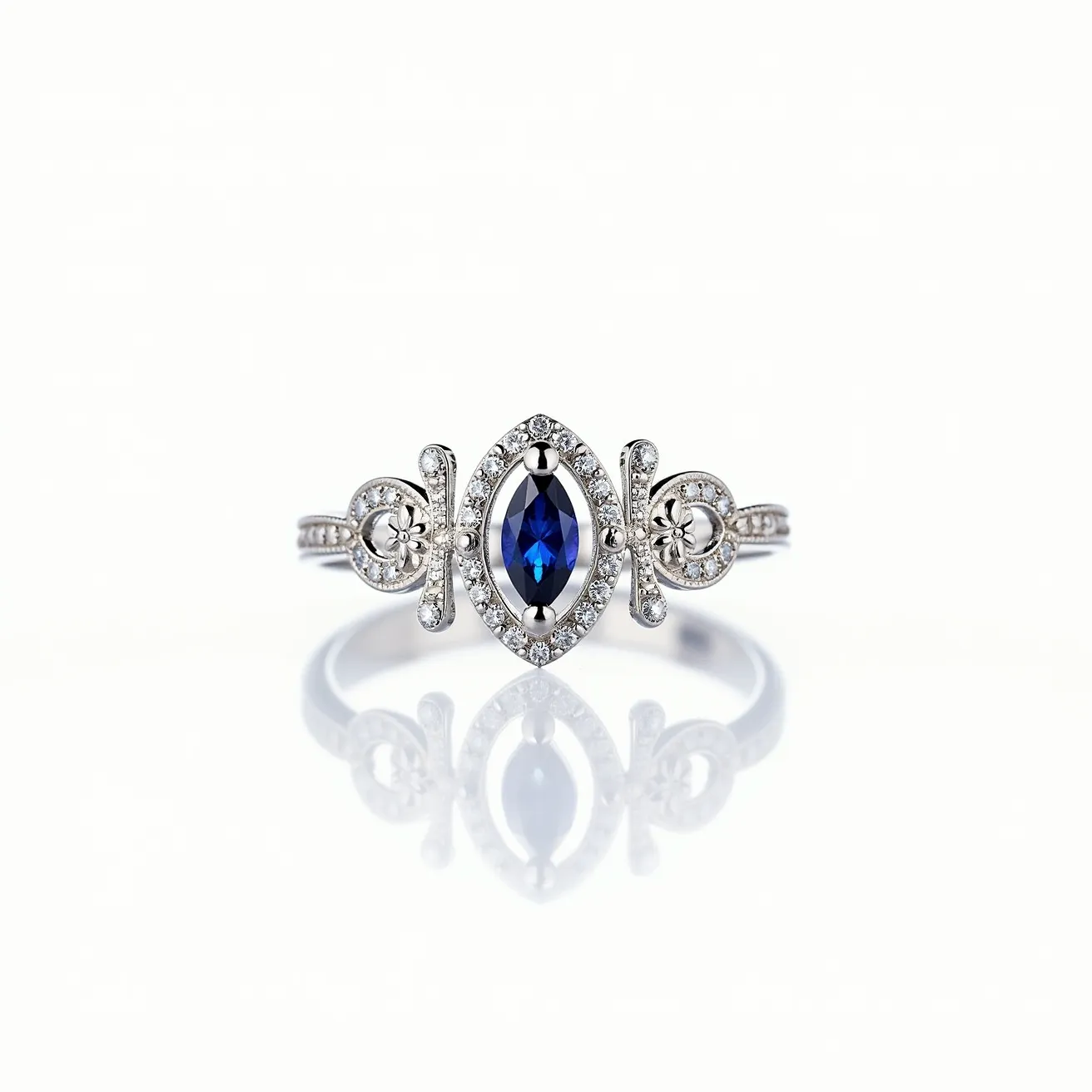 This crown ring features a central marquise-cut blue sapphire, elegantly set in a bezel setting. The sapphire is surrounded by a halo of small, round brilliant-cut diamonds that continue onto the shank, adding a touch of brilliance and sophistication. Ornate detailing flanks the centerpiece, incorporating filigree-like elements that enhance the regal aesthetic of the design. The band of the ring appears to be crafted from white gold, complementing the cool tones of the gemstones and highlighting the intricate metalwork. This combination of precious materials and craftsmanship creates a stunning piece of jewelry reminiscent of a royal crown.