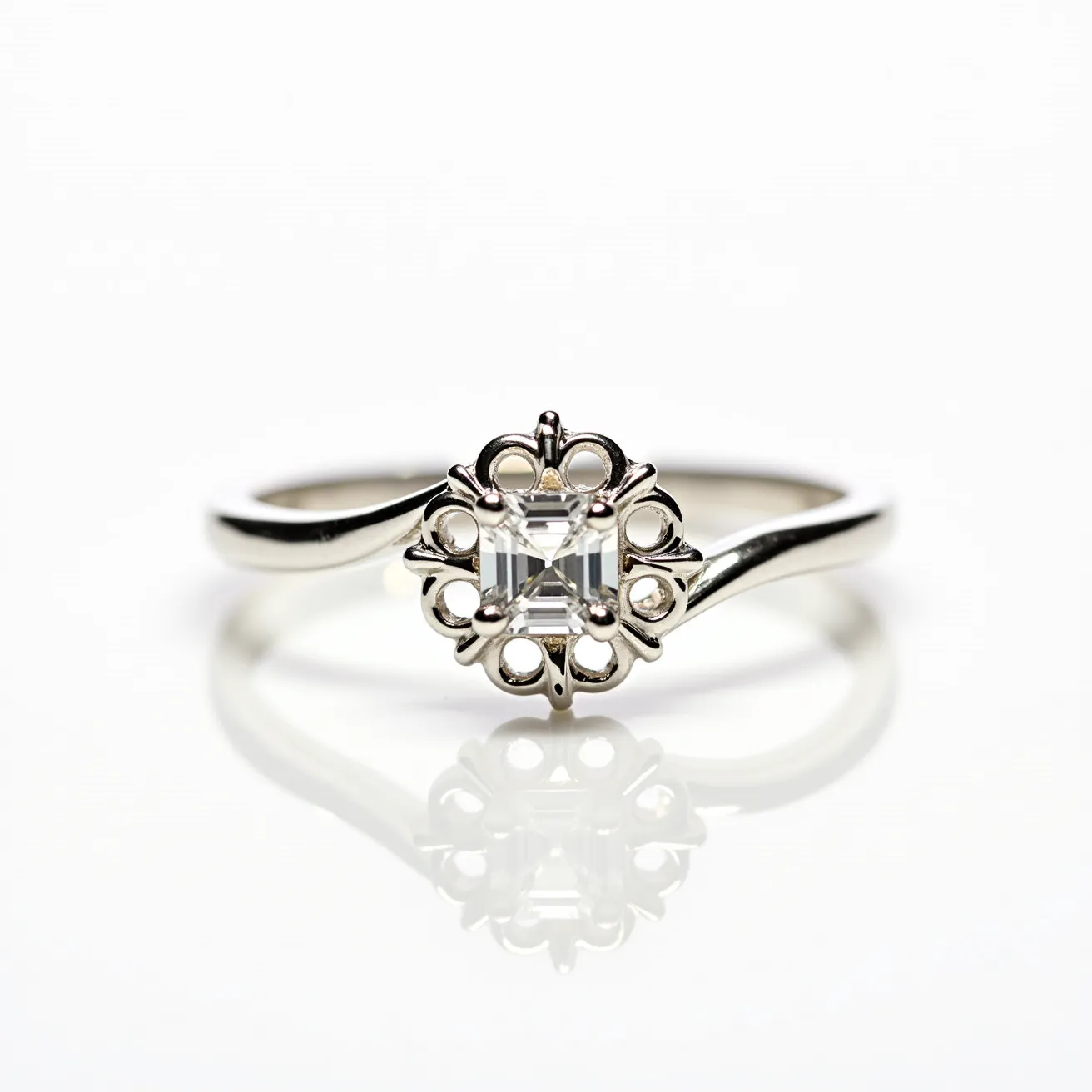 This crown ring features a sleek metal band, likely crafted from silver or white gold, that gracefully supports a central gemstone. The centerpiece appears to be a square-cut gem, possibly an Asscher-cut diamond, skillfully set within a detailed crown-like setting. The intricate setting surrounds the gemstone with delicate loops and points, enhancing its regal appearance. The overall design of the ring, with its focus on symmetry and elegance, accentuates the brilliance of the central stone, making it a striking piece for any occasion.