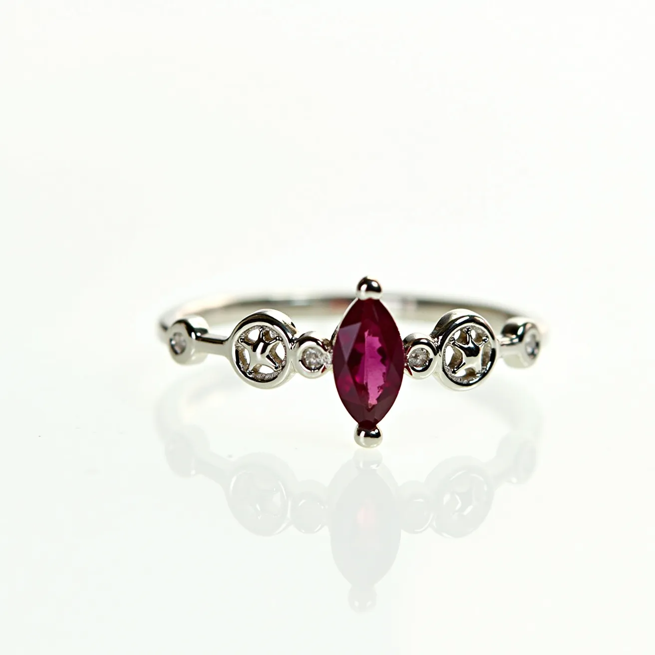 This custom ring features a sleek metal band, possibly silver or white gold, adorned with an exquisite marquise-cut red gemstone at its center, likely a ruby or garnet, held securely in place by a prong setting. The band's design incorporates small circular cutouts with delicate metalwork, interspersed with tiny round stones that may be diamonds, adding a touch of sparkle. The arrangement and craftsmanship of the elements on the ring suggest a balance of elegance and intricate detailing, making it a unique piece.