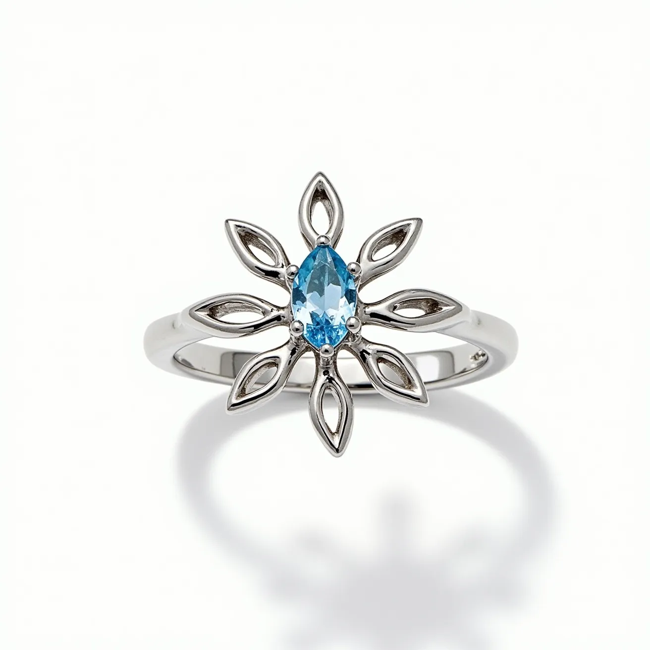 This daisy ring features a central marquise-cut blue gemstone, likely topaz or aquamarine, set in a prong setting. The band is crafted from a silver-toned metal, possibly sterling silver or white gold, which forms petal-like shapes around the central stone. These petal shapes add an organic and floral-inspired design element that enhances the daisy motif of the ring. There is no clasp or additional attachment, as the ring is designed for a simple and elegant presentation.