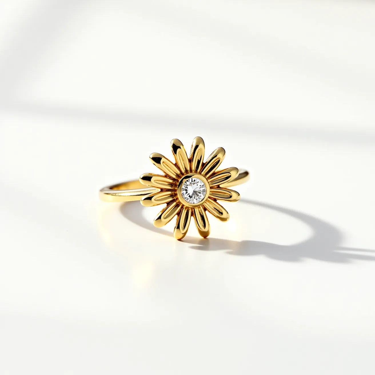 This daisy ring is crafted from gold, forming the shape of a daisy flower with layered petals. At the center of the flower is a round-cut diamond, securely set in a bezel setting that complements the floral design. The band of the ring is smooth and seamlessly blends with the intricately detailed flower, showcasing a harmonious combination of elegance and nature-inspired beauty. The central diamond adds a brilliant sparkle, enhancing the overall aesthetic of this charming piece of jewelry.