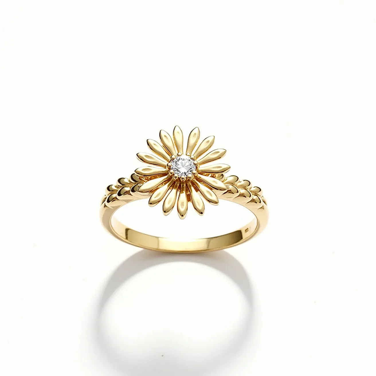 This daisy ring showcases a beautifully crafted floral design made of gold. The petals of the daisy are elegantly arranged around a central gem, which appears to be a round-cut diamond, secured in a bezel setting. The band of the ring echoes the floral theme with additional detailing that complements the daisy motif. The overall design is both sophisticated and playful, capturing the essence of a blooming daisy in a piece that is both charming and elegant.