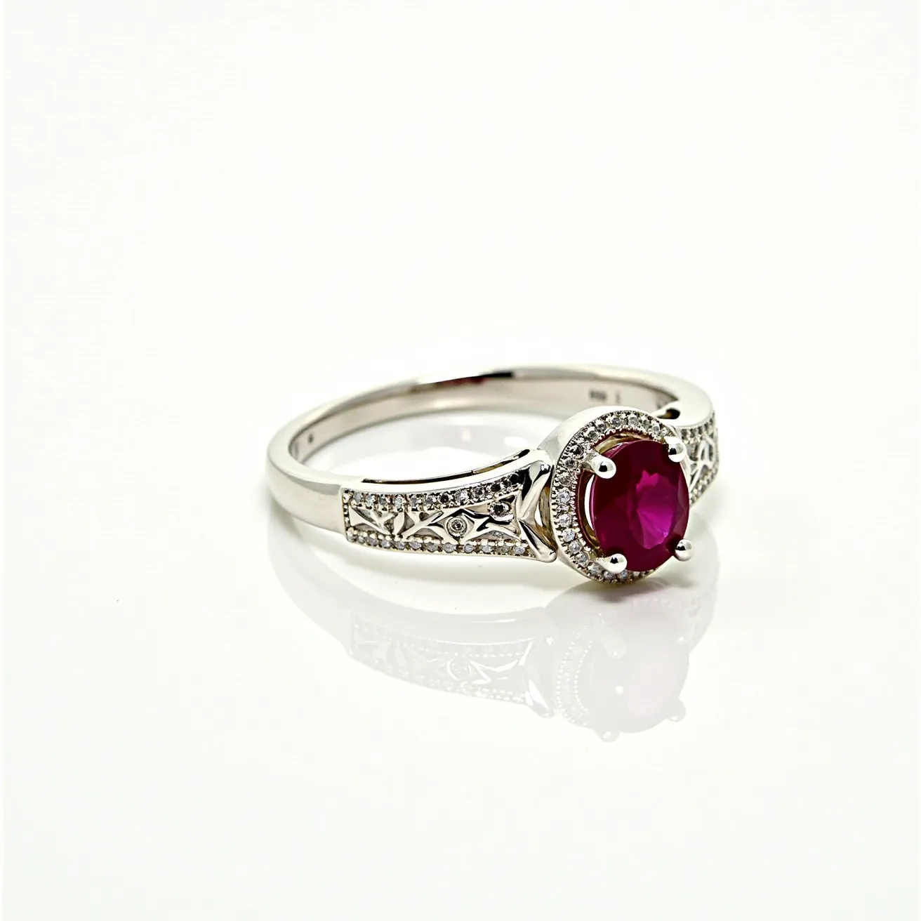 This diamond ring showcases a stunning design with a vibrant red gemstone, likely a ruby, held securely in a four-prong setting. The band is crafted from a polished metal, possibly white gold or platinum, featuring intricate detailing along the sides. Surrounding the central ruby are small round-cut diamonds that form a halo, adding brilliance and emphasizing the center stone. The band itself is adorned with additional small diamonds set into the metal, enhancing the overall elegance and sparkle of the piece.