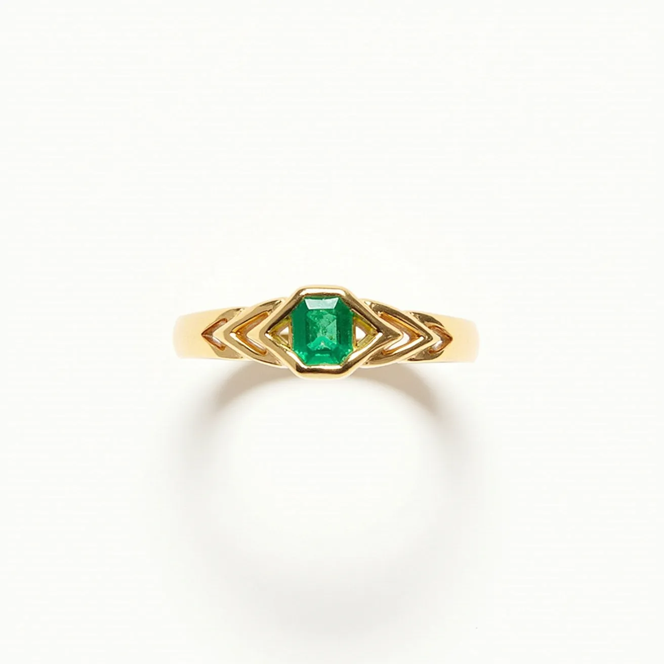 This emerald birthstone ring features a striking, rectangular-cut emerald set in the center, which is encased in a gold band. The geometric design around the stone adds a modern touch, enhancing the vibrant green of the emerald. The setting is clean and secure, highlighting the stone's beauty while ensuring it is held firmly in place. Crafted with polished gold, the ring possesses an elegant and timeless appeal, making it a perfect piece for those who appreciate both classic and contemporary jewelry design.