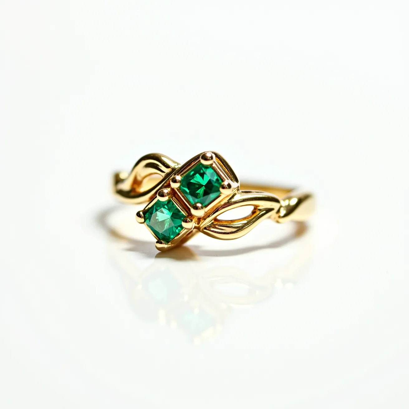 This emerald birthstone ring features two vibrant emerald gemstones, each cut in a square shape, capturing the light with pristine clarity. They are elegantly set in a polished, twisted gold band that forms an intricate intertwined design. The stones are securely held in place by a four-prong setting that accentuates their lush green hue. The band itself is crafted from a warm gold material, which complements the rich color of the emeralds, creating a harmonious and sophisticated aesthetic.